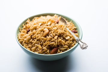 Traditional Jaggery Rice or Gur wale chawal in Hindi, served in a bowl with spoon. selective focus
