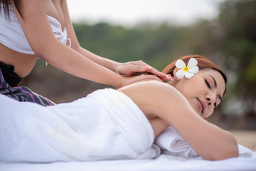 Obraz na płótnie Canvas Beautiful asian woman enjoying spa massage therapy on the beach.