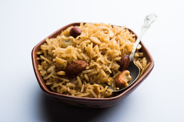 Traditional Jaggery Rice or Gur wale chawal in Hindi, served in a bowl with spoon. selective focus