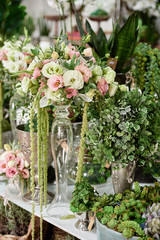Many flowers on table in florist shop, copy space. Small business. Floral design studio, luxury wedding decorations and arrangements. Flowers delivery. Holiday and floristry concept