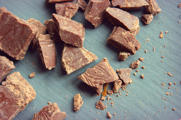 Pieces of delicious dark chocolate on wooden board