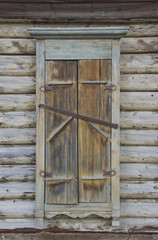 The window of an old wooden house, closed with shutters