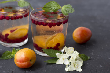 Fresh cool detox drink with berries and peaches or aprikotes.