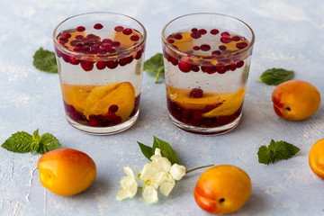 Fresh cool detox drink with berries and peaches or aprikotes