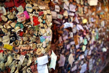 A brick wall covered in used chewing gum with lovers autographs. stucked used bubble gums and...