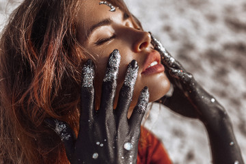 close-up van mooie jonge vrouw met handen zwart geverfd. maan en sterren concept
