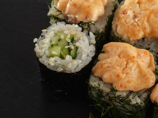 sushi rolls on gray stone slate on wood background