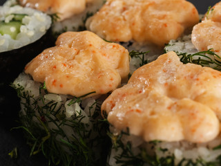 sushi rolls on gray stone slate on wood background