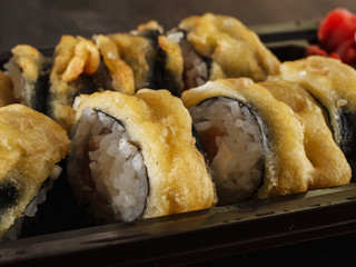 sushi rolls on gray stone slate on wood background