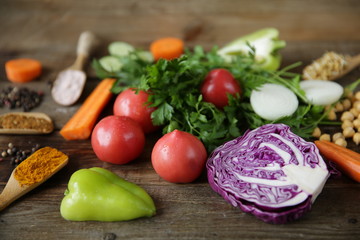 Organic healthy food, fresh vegetables, greens, sprouted fenugreek bean seeds and chickpeas and other spices on a wooden table. The concept of healthy eating. Ingredients for cooking.