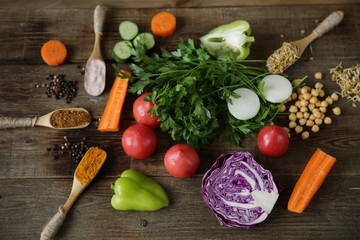 Top view. Flat lay. Organic Healthy Food, Fresh vegetables, greens, germinated legumes, spices on a wooden table. The concept of healthy eating. Ingredients for cooking.