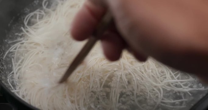 Cooking with somen on skillet in the kitchen