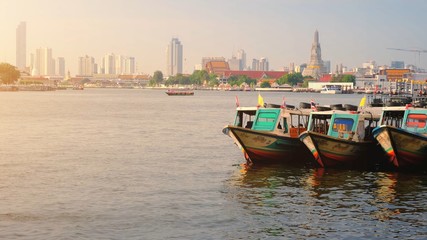Fototapeta na wymiar Colorful Passenger Boats Docked with Wat Arun at on the Chao Phraya River.