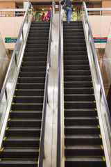 Unidentified people using underground MRT escalator in Singapore.