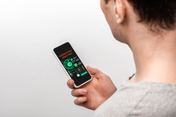 cropped view of man using smartphone with marketing analysis app, isolated on grey