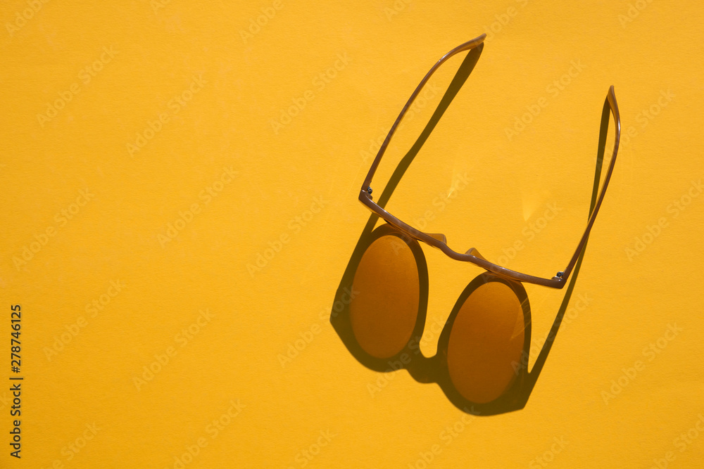 Canvas Prints sunglasses with long shadow on a brignt summer yellow background