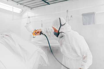 Working in modern car painting chamber.