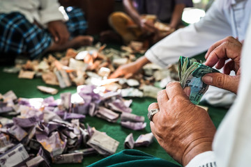 A group of men counting charity money at a mosque.