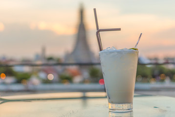 cocktail on table in rooftop bar with famous place background.