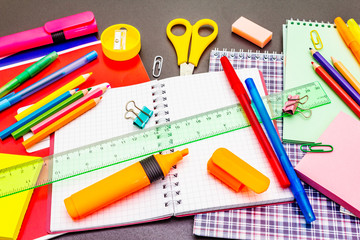 Back to school concept. School education supplies on black stone concrete background.