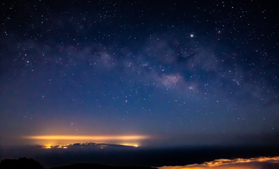 Fototapeta na wymiar Fantastic shot of the Milky Way over a lit island