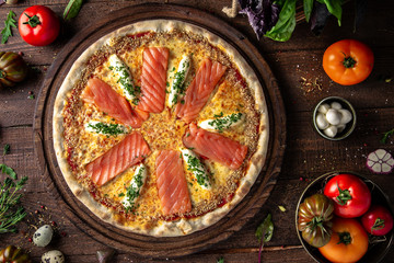 Tasty hot italian pizza Al salmon with Salmon, Philadelphia cheese, Mozzarella, Parsley, Sesame, Tomato Saucewith on old wooden table. Pizzeria menu. Concept poster for Restaurants or 