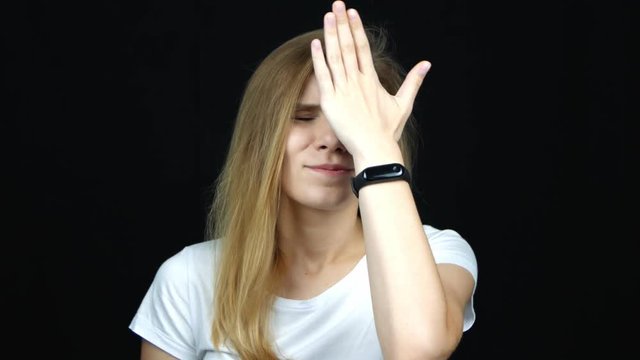 Portrait of annoyed caucasian woman covering face like facepalm expressing frustration or shame, over black background. Concept of emotions. Close up.