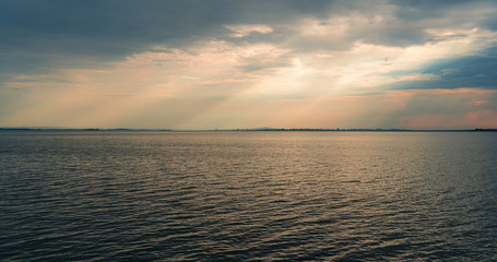 Fototapeta premium Seascape. Evening overcast sky and the rays of the sun.