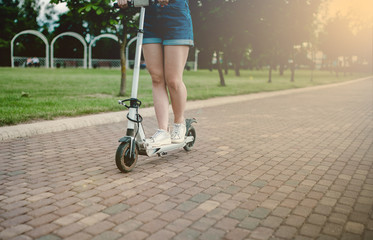 Electric scooter for a girl in the city. eco-friendly transport is an alternative to a car in the city, combating traffic congestion.