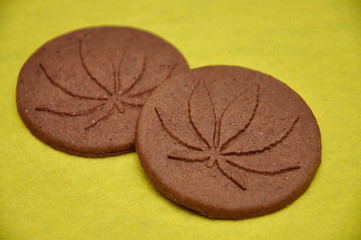 Two golden brown cannabis biscuits with cannabis leave prints