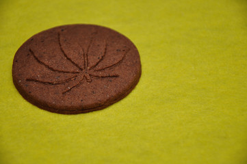 Obraz na płótnie Canvas A golden brown cannabis biscuit with a cannabis leave print