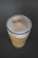 large transparent glass filled with of aromatic coffee photographed on the isolated gray background picture for the menu.
