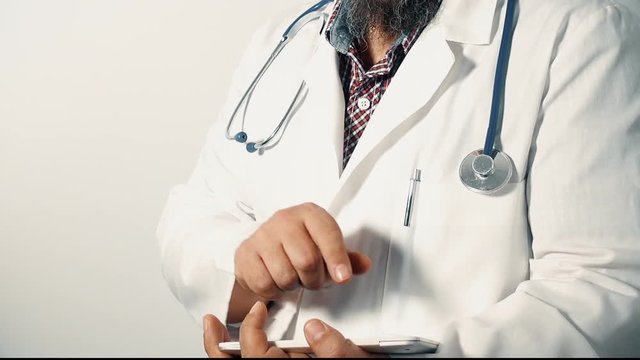 Physician holding a digital tablet, looking at the camera, zoom out