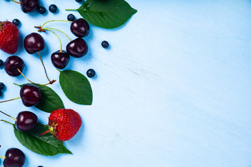 Ripe berries on a blue wooden background.