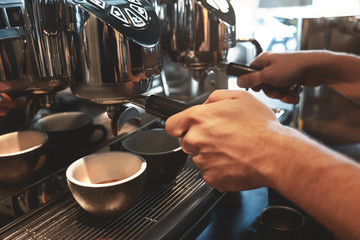 barista man making two cups of coffee drink at the same time using professional coffee machine in...