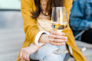 Female holding glass of white wine