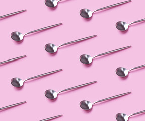 Pattern with trendy silver spoons on pink background