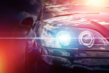 Modern car headlight with blue light effect and red sun light effects - obrazy, fototapety, plakaty