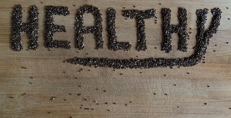 Healthy Food written with chia and oats on a wooden board. Vegetable banner.