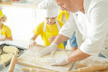 Children cook in the kitchen. Happy child learns to cook in the kitchen delicious chef chef. 