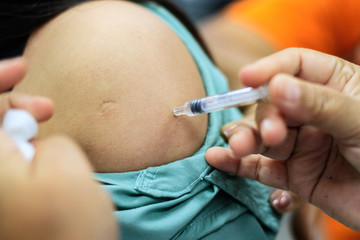 Nurse  making a vaccination to the shoulder of patient