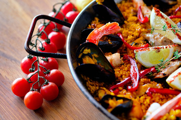 Delicious Spanish seafood paella, view from top. Cooked with sturgeon halibut fillet, peeled...