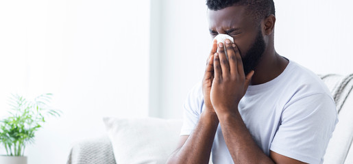 African-american man man has runny nose at home