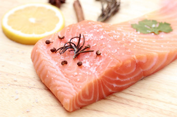 Raw salmon slices with ingredient for cooking on kitchen plate 