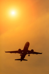 Fototapeta na wymiar Silhouette comercial airplane flying on sunset.