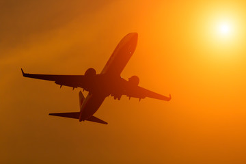 Fototapeta na wymiar Silhouette comercial airplane flying on sunset.