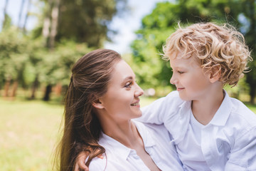 Fototapeta premium beautiful happy mother looking at adorable son in park