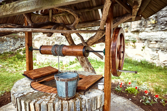 Water well with a wooden roof and a bucket.