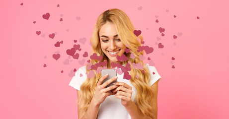 Obraz na płótnie Canvas Happy woman holding mobile phone with many hearts