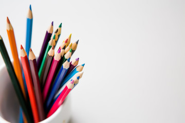 colored pencils empty notebook, top view, space for text